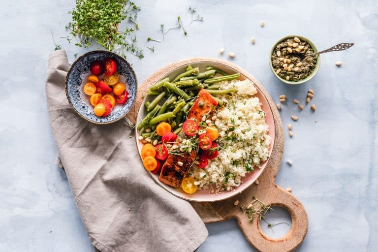 PCOS-friendly meal with salmon, quinoa, avocado, and leafy greens, supporting blood sugar balance.