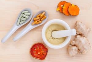 Berberine capsules, turmeric root, and powdered supplements arranged on a neutral background, representing supplements often discussed in PCOS care