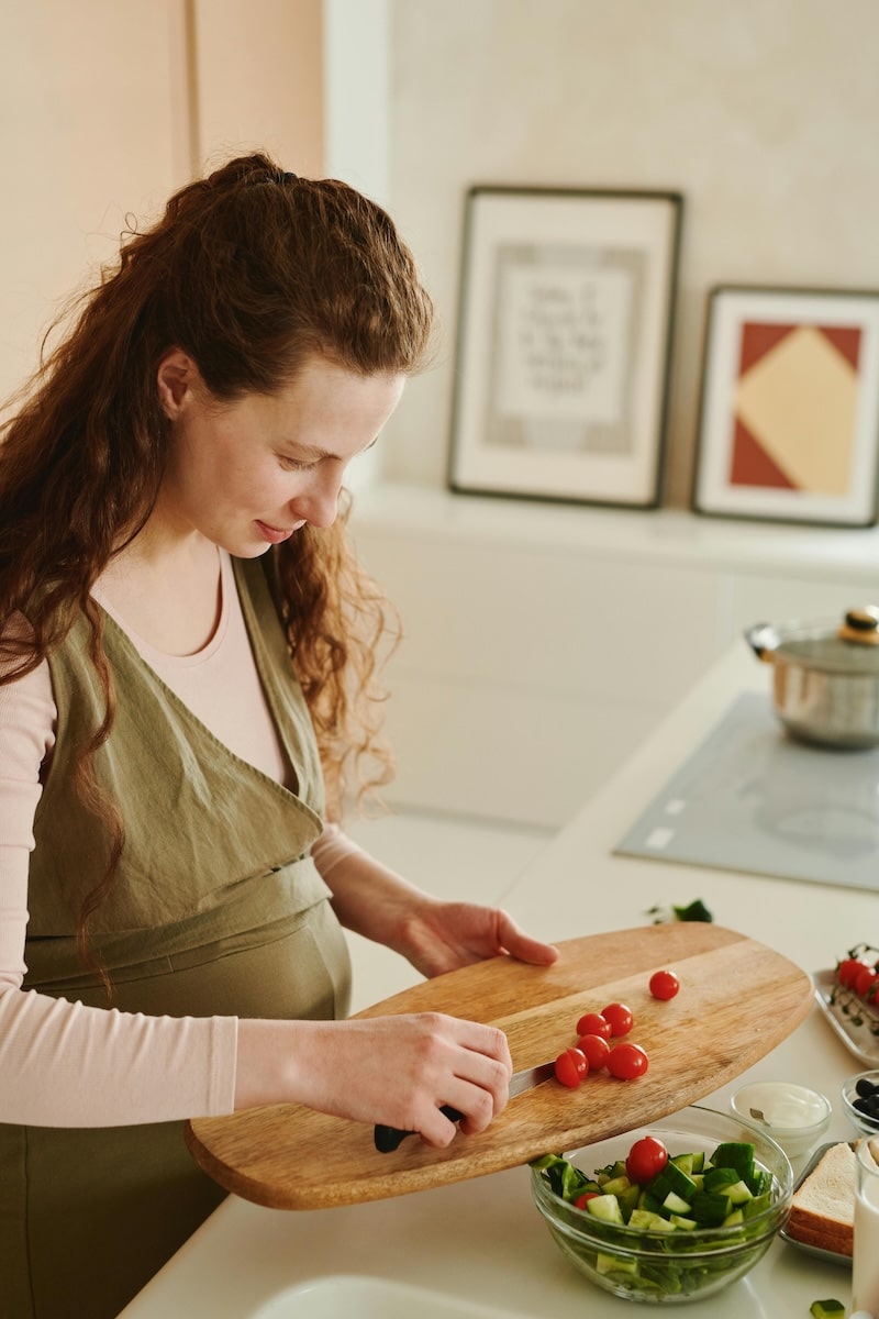 Pregnant woman in a cozy kitchen preparing a healthy bedtime snack.