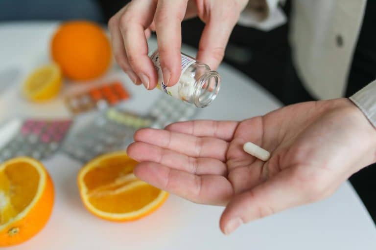 Woman pouring collagen supplement into her hand, representing daily routine for PCOS support.