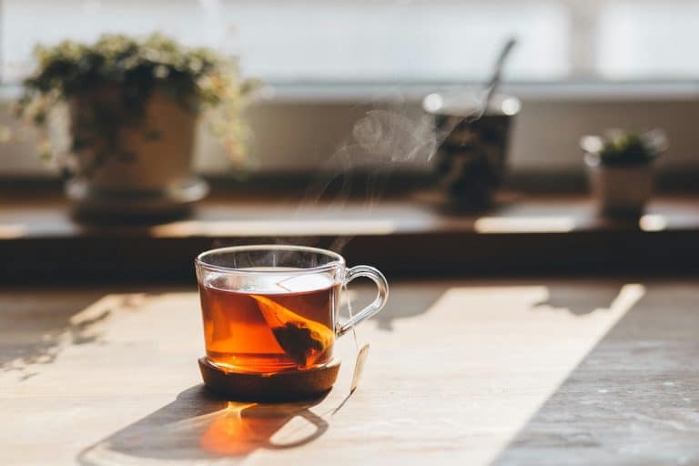 A steaming cup of herbal tea sitting by a sunny window—an inviting example of the best teas for PCOS to support hormone balance and relaxation.